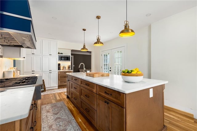 711 Greenview Ave NE, Atlanta, GA 30305 - kitchen featuring stainless steel microwave, white cabinetry, light wood-type flooring, and a sink