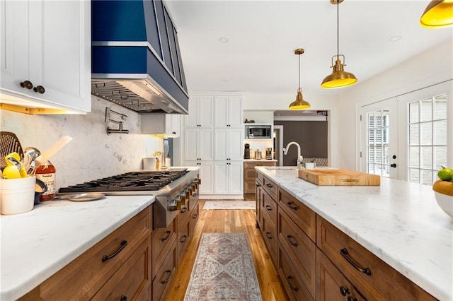 711 Greenview Ave NE, Atlanta, GA 30305 - kitchen featuring stainless steel appliances, light wood-type flooring, white cabinetry, and brown cabinets