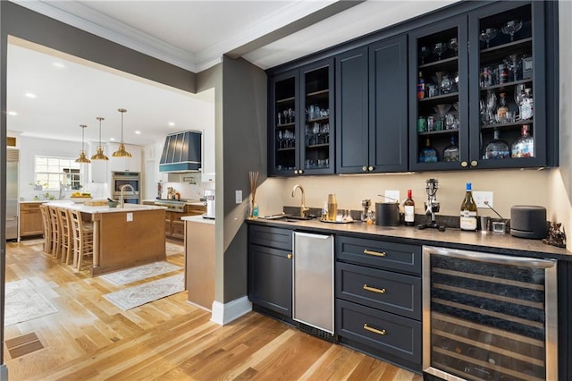 711 Greenview Ave NE, Atlanta, GA 30305 - indoor wet bar featuring wine cooler, stainless steel appliances, crown molding, light wood finished floors, and custom exhaust hood