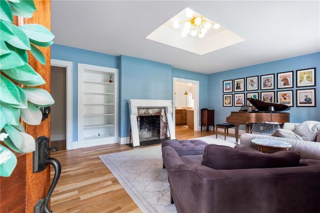 711 Greenview Ave NE, Atlanta, GA 30305 - living area featuring built in features, wood finished floors, a fireplace, a skylight, and baseboards