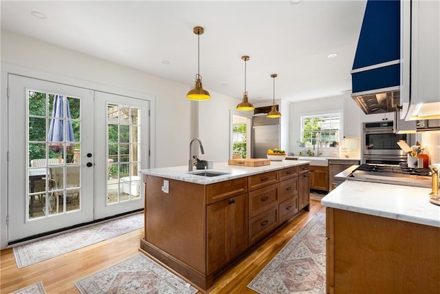 711 Greenview Ave NE, Atlanta, GA 30305 - kitchen featuring a sink, light wood finished floors, brown cabinetry, appliances with stainless steel finishes, and recessed lighting