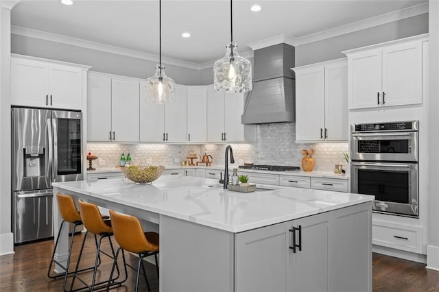 2208 Sage Mountain Ct SW, Marietta, GA 30064 - kitchen featuring stainless steel appliances, wall chimney exhaust hood, dark wood-style flooring, a center island with sink, and crown molding