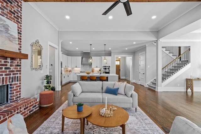2208 Sage Mountain Ct SW, Marietta, GA 30064 - living room featuring a ceiling fan, dark wood finished floors, crown molding, stairway, and a brick fireplace