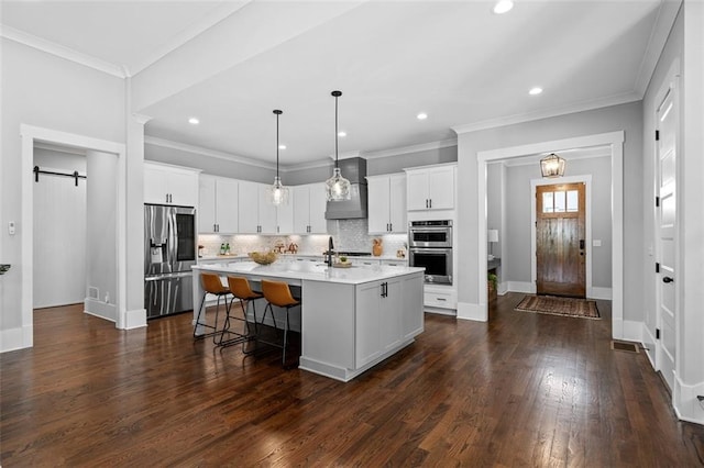 2208 Sage Mountain Ct SW, Marietta, GA 30064 - kitchen featuring stainless steel appliances, wall chimney range hood, light countertops, a barn door, and backsplash