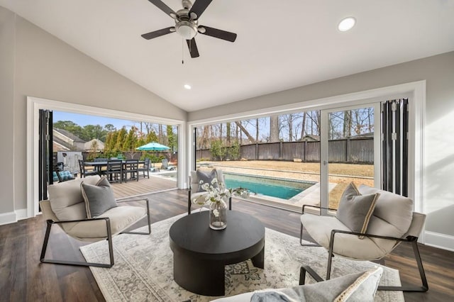 living room featuring lofted ceiling, ceiling fan, dark hardwood / wood-style flooring, and a healthy amount of sunlight