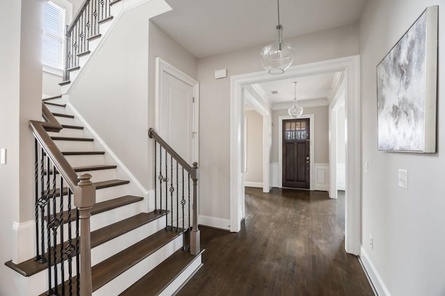 foyer with dark wood-type flooring and ornamental molding