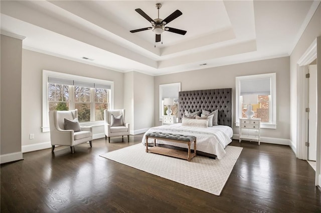 bedroom with ceiling fan, a tray ceiling, and dark hardwood / wood-style flooring