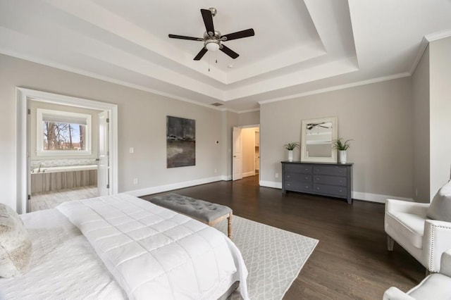 bedroom featuring ornamental molding, dark wood-type flooring, connected bathroom, and a tray ceiling