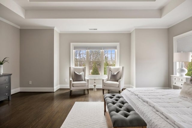 bedroom with dark hardwood / wood-style flooring, a tray ceiling, and ornamental molding