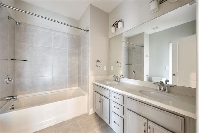 bathroom featuring tiled shower / bath combo, vanity, and tile patterned floors