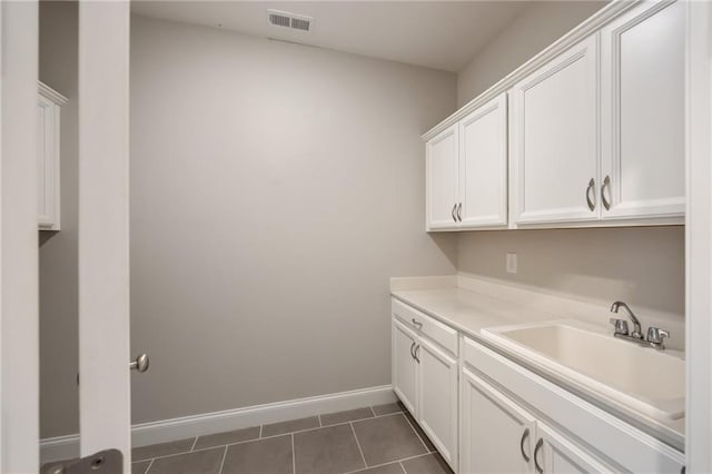 laundry room with sink and dark tile patterned flooring