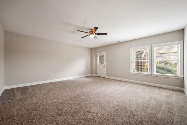 carpeted spare room featuring ceiling fan