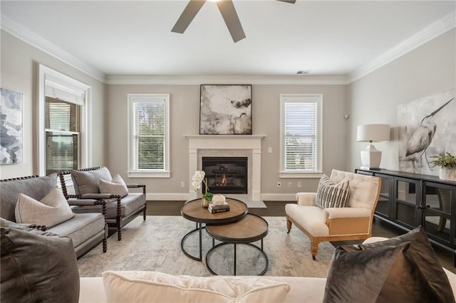 living room featuring crown molding, a fireplace, light hardwood / wood-style floors, and ceiling fan