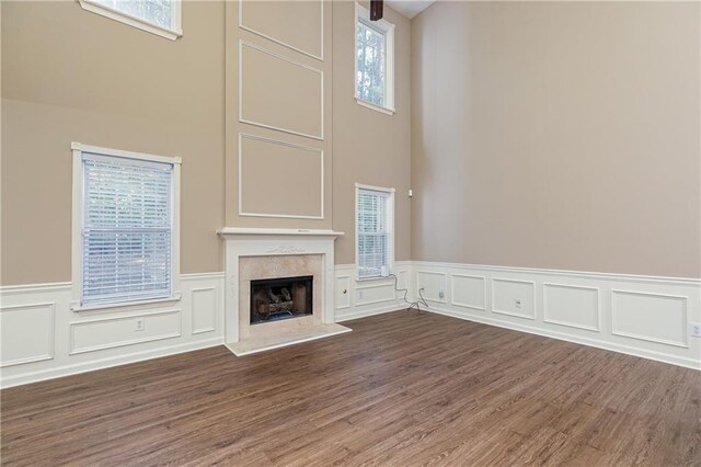 1731 Silverchase SW, Marietta, GA 30008 - unfurnished living room featuring a wainscoted wall, plenty of natural light, a fireplace with raised hearth, and wood finished floors