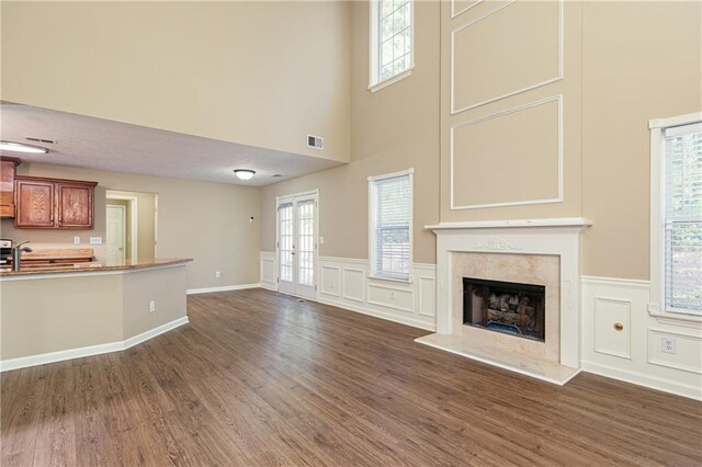 1731 Silverchase SW, Marietta, GA 30008 - unfurnished living room featuring dark wood-style flooring, a decorative wall, visible vents, and a premium fireplace