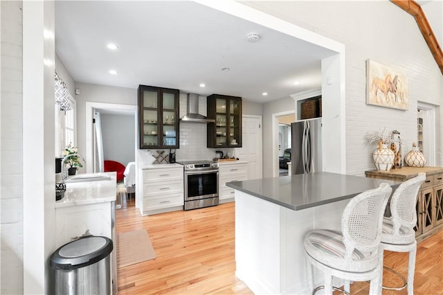 1359 Scott Blvd, Decatur, GA 30030 - kitchen with stainless steel appliances, wall chimney range hood, a sink, light wood-type flooring, and glass insert cabinets