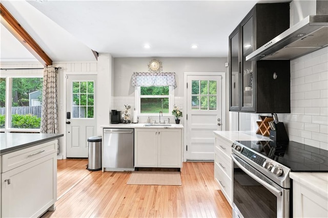 1359 Scott Blvd, Decatur, GA 30030 - kitchen with stainless steel appliances, wall chimney range hood, a sink, tasteful backsplash, and light wood-style floors