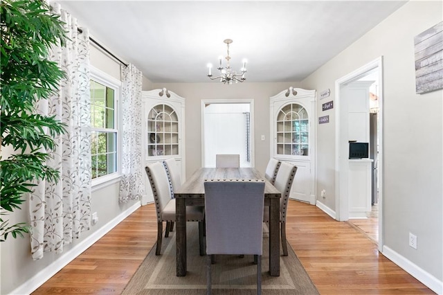 1359 Scott Blvd, Decatur, GA 30030 - dining room featuring a chandelier, light wood-style floors, and baseboards