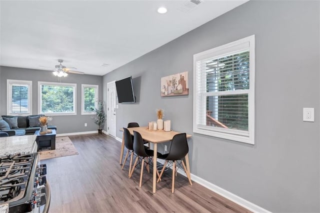 dining area featuring wood finished floors, baseboards, a ceiling fan, and visible vents