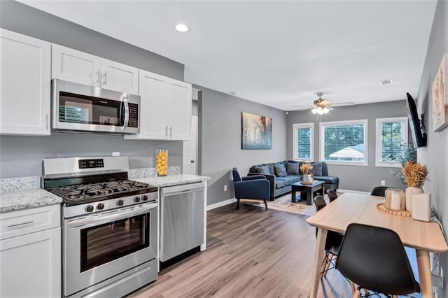 kitchen featuring light hardwood / wood-style floors, white cabinetry, ceiling fan, and stainless steel appliances