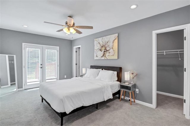 bedroom featuring a spacious closet, carpet flooring, french doors, and baseboards