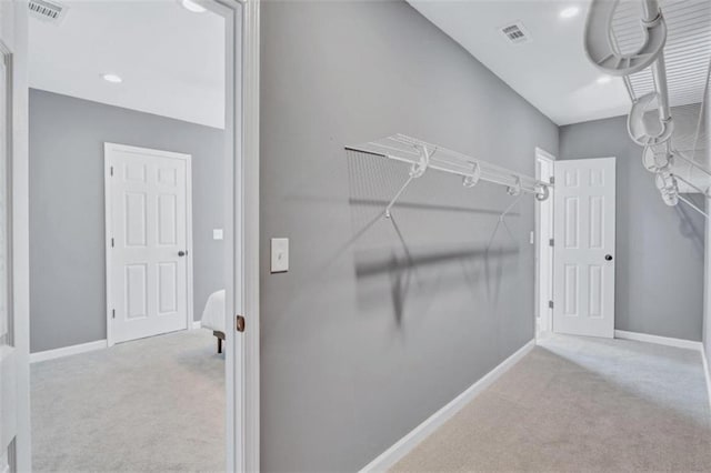 walk in closet featuring light colored carpet