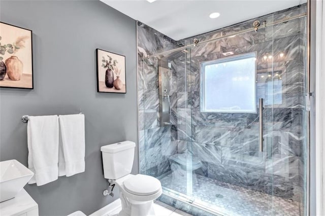 full bath featuring a marble finish shower, toilet, and a sink