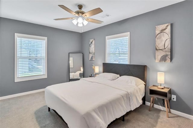 carpeted bedroom with ceiling fan, baseboards, and visible vents