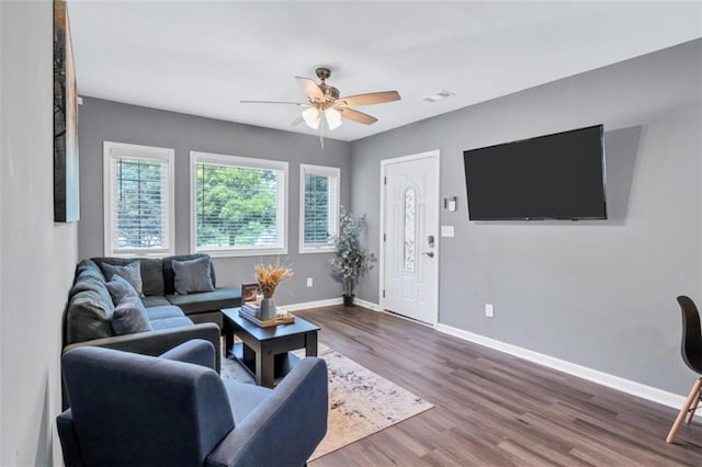 living area featuring visible vents, ceiling fan, wood finished floors, and baseboards