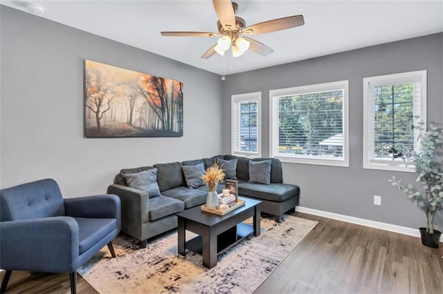 living area featuring ceiling fan, baseboards, and wood finished floors