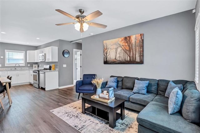 living area featuring wood finished floors, ceiling fan, baseboards, and recessed lighting