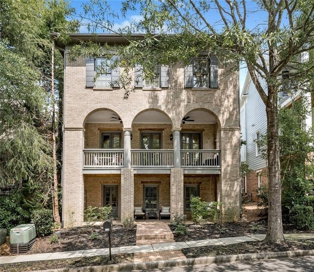 view of front of home featuring a balcony, french doors, and cooling unit