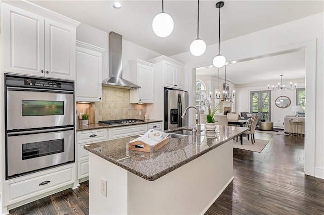 kitchen with backsplash, dark hardwood / wood-style flooring, white cabinetry, stainless steel appliances, and wall chimney range hood