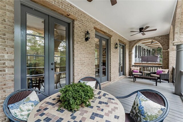 wooden deck featuring ceiling fan and french doors