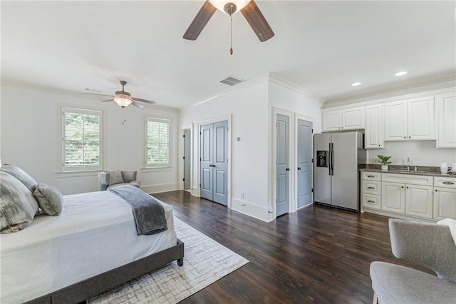 bedroom featuring ceiling fan, stainless steel refrigerator with ice dispenser, dark hardwood / wood-style flooring, multiple closets, and crown molding