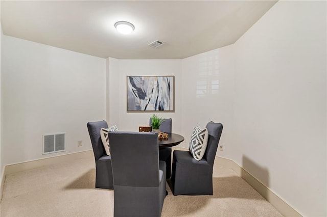 dining space featuring light carpet