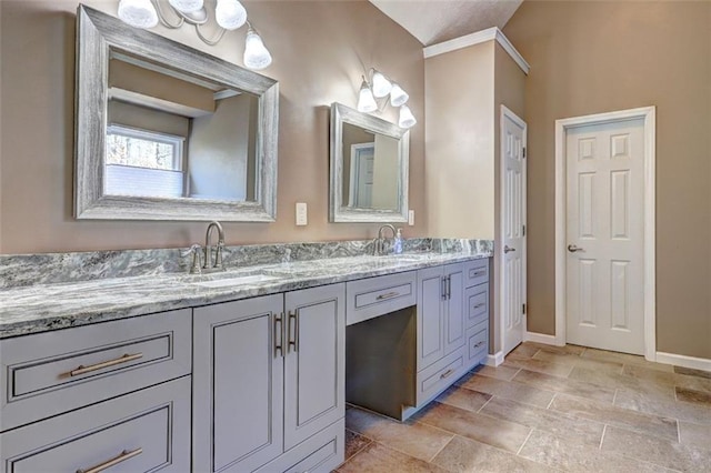 full bath featuring double vanity, baseboards, and a sink