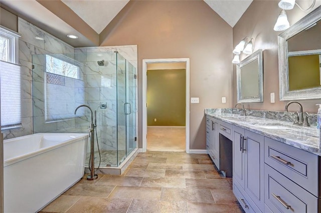 full bathroom featuring lofted ceiling, a shower stall, double vanity, and a sink