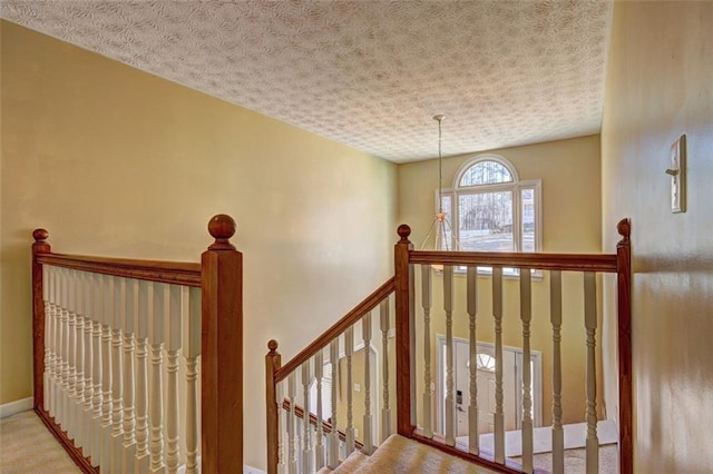 staircase with a textured ceiling