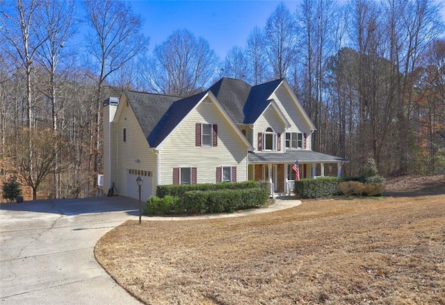 view of front facade featuring a garage, concrete driveway, and a porch