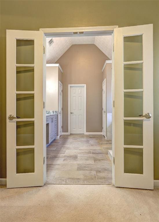 interior space with built in features, lofted ceiling, visible vents, and baseboards