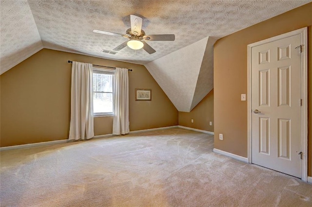 additional living space featuring a textured ceiling, carpet flooring, and visible vents