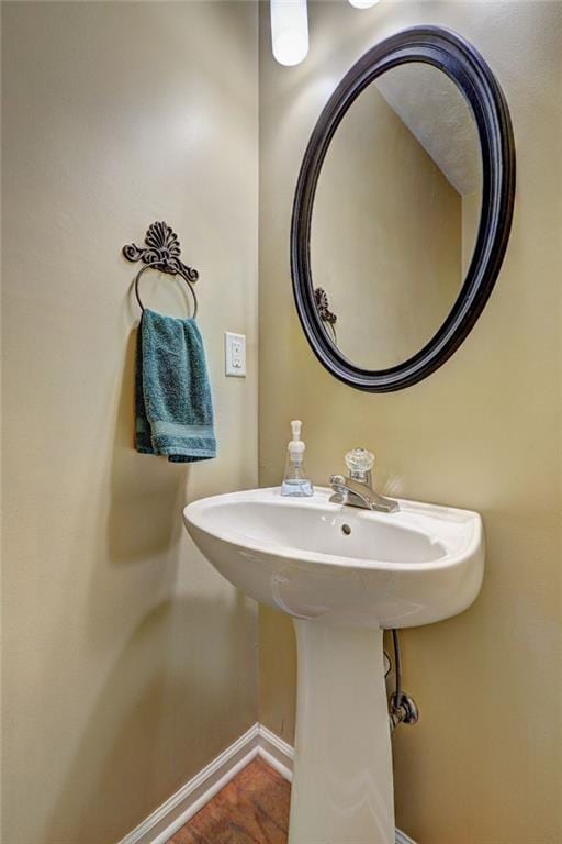 bathroom with a sink and baseboards