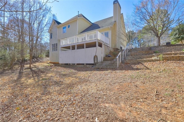 rear view of house featuring stairs and a chimney