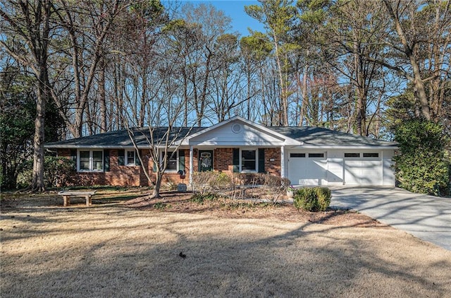 single story home with driveway, a garage, and brick siding