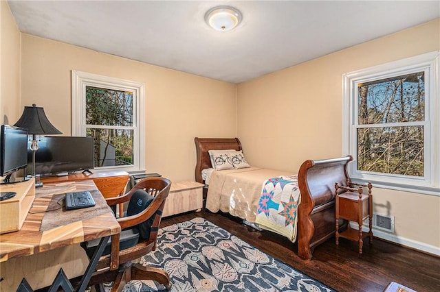 bedroom with visible vents, baseboards, and wood finished floors