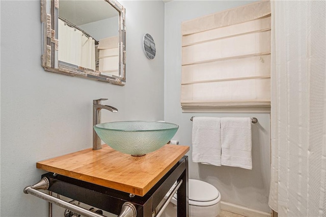 full bathroom with a closet, vanity, and toilet