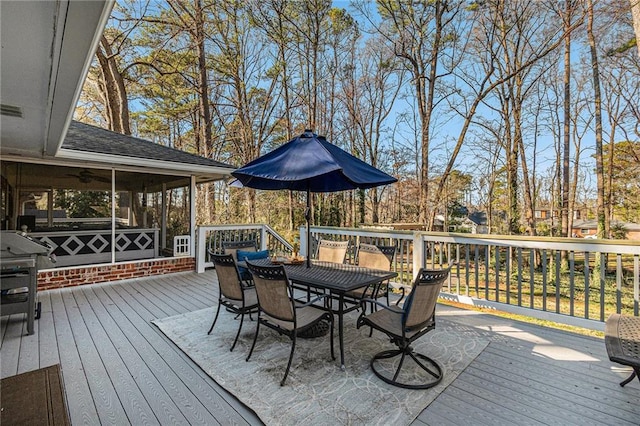 deck with a sunroom and outdoor dining space