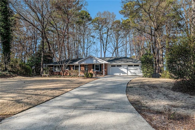 single story home featuring a garage, concrete driveway, and brick siding