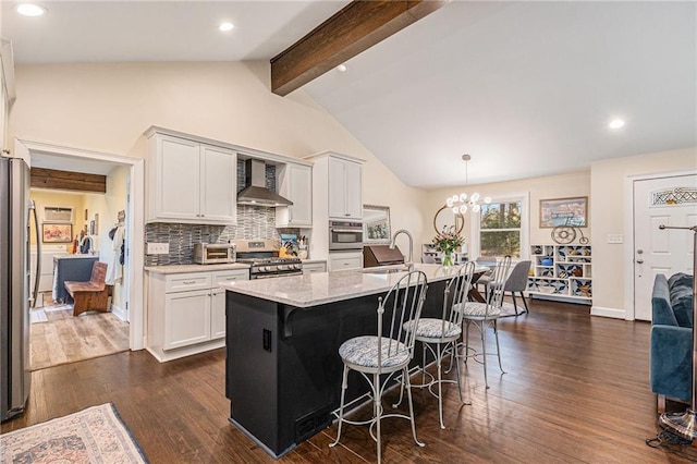 kitchen with white cabinets, wall chimney exhaust hood, dark wood-style flooring, stainless steel appliances, and a sink